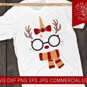 May include: White t-shirt featuring a whimsical design combining a unicorn horn, reindeer antlers, and round glasses. The design includes a red bow tie, a lightning bolt, and a scarf in shades of red and orange. The shirt has the text "SVG DXF PNG EPS JPG COMMERCIAL USE".
