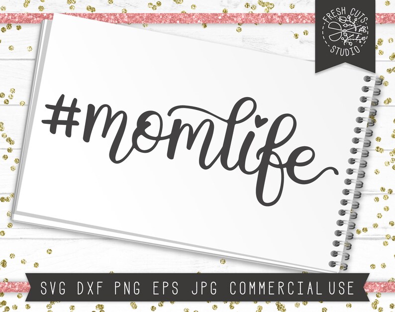 May include: A black and white graphic design with the text "#momlife" in a cursive font. The text includes a small heart symbol.