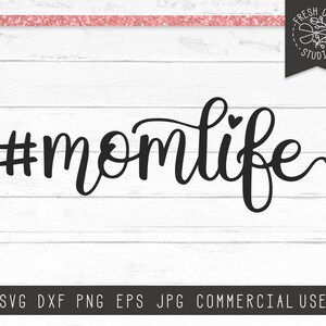 May include: Black and white graphic design with the text "#momlife" in a cursive font with a small heart above the "o".