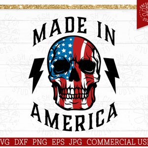 May include: A black and white graphic design with the text "Made in America" in bold black letters. A skull with the American flag design is in the center of the graphic. Two lightning bolts are on either side of the skull.