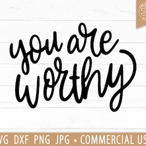 May include: Black and white calligraphy text on a white wood background. The text reads "you are worthy".