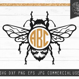 May include: Black and white silhouette of a bee with a gold circle monogram in the center. The monogram reads "ABC".