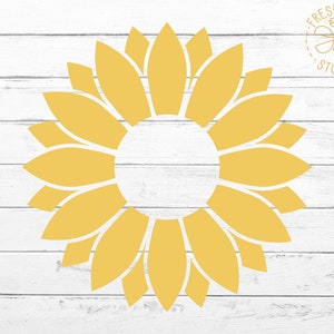 May include: A yellow sunflower design on a white wooden background. The sunflower has a circular center and elongated petals. The image includes the text "FRESH CUTS STUDIO" in a circular design.