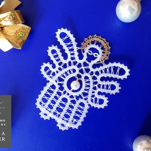 May include: White bobbin lace angel ornament with a gold halo and a pearl bead. The angel is on a blue background.