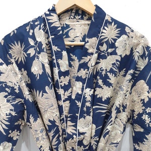 May include: A navy blue robe with a white floral pattern. The robe has a white piping trim around the edges and a tie belt.