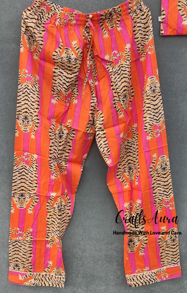 May include: Orange and pink striped pajama pants with a tiger print. The pants have a drawstring waist and are made of a soft, comfortable fabric.