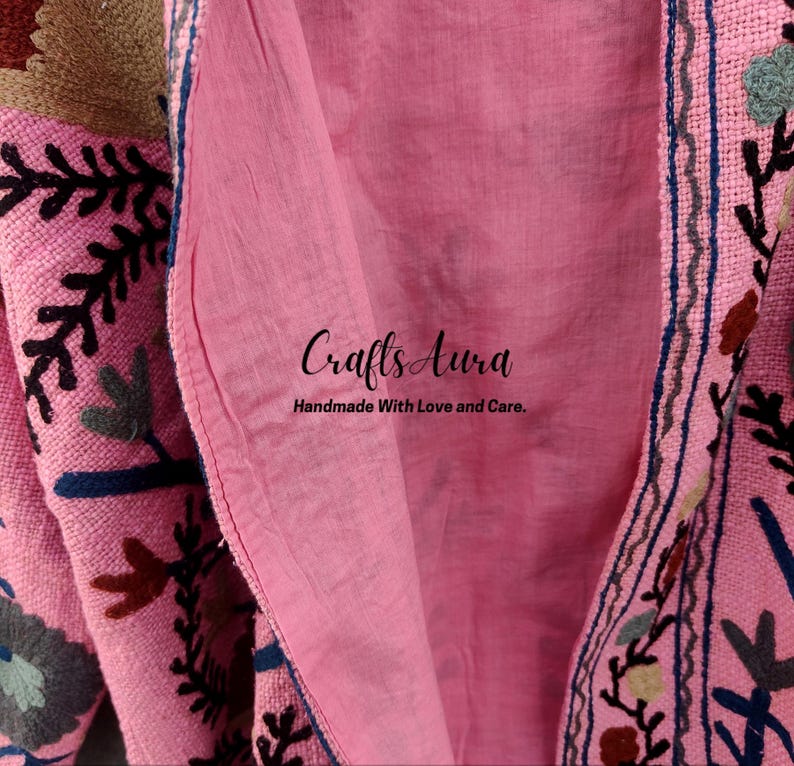 May include: Pink fabric with floral embroidery and the text "Crafts Aura Handmade With Love and Care."