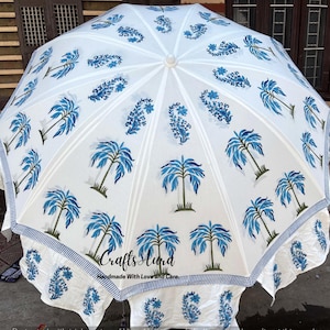 Könnte beinhalten: Ein weißer Sonnenschirm mit blauem Palmen- und Blumenmuster. Der Schirm hat einen gestreiften Rand und den Text "Crafts Aura Handmade With Love and Care".