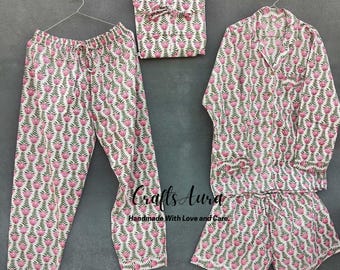May include: A pink and white floral print pajama set with a long-sleeved shirt, pants, and shorts. The set is made of cotton and has a comfortable fit.