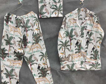 May include: A white pajama set with a jungle-themed print featuring leopards, zebras, toucans, and palm trees. The set includes a button-down shirt, pants, and a matching pouch, all hanging on separate hangers.