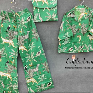 Könnte beinhalten: Grüner Pyjama-Set mit Dschungel-Print mit Leoparden, Tukanen und Palmen. Das Set beinhaltet ein langärmliges Hemd und eine weite Hose. Das Hemd hat einen Kragen und einen Knopfverschluss. Die Hose hat einen elastischen Bund. "Crafts Aura Handgefertigt mit Liebe und Sorgfalt."