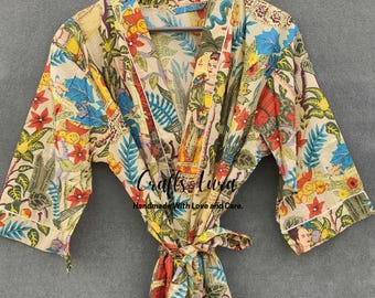 May include: A beige robe with a colorful floral and figure print. The robe has a tie closure and white trim on the sleeves. The text "Crafts Luvd Handmade With Love and Care" is printed on the robe.
