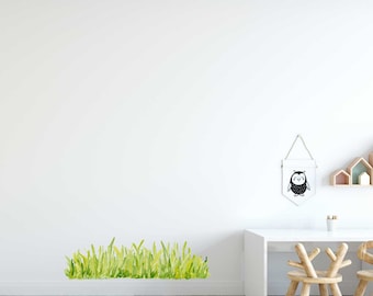 Può includere: Un muro bianco con un adesivo di erba verde, un tavolo bianco con due sedie di legno e uno stendardo di gufo bianco e nero appeso al muro.