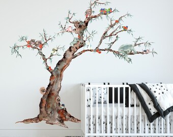 May include: A watercolor-style wall decal featuring a tree with a variety of animals, including koalas, birds, and squirrels. The decal is perfect for a nursery or child's room.