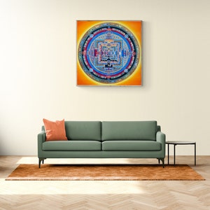 Puede incluir: Un sofá verde con un cojín naranja frente a una pared blanca con una pintura de mandala colorida colgada encima.