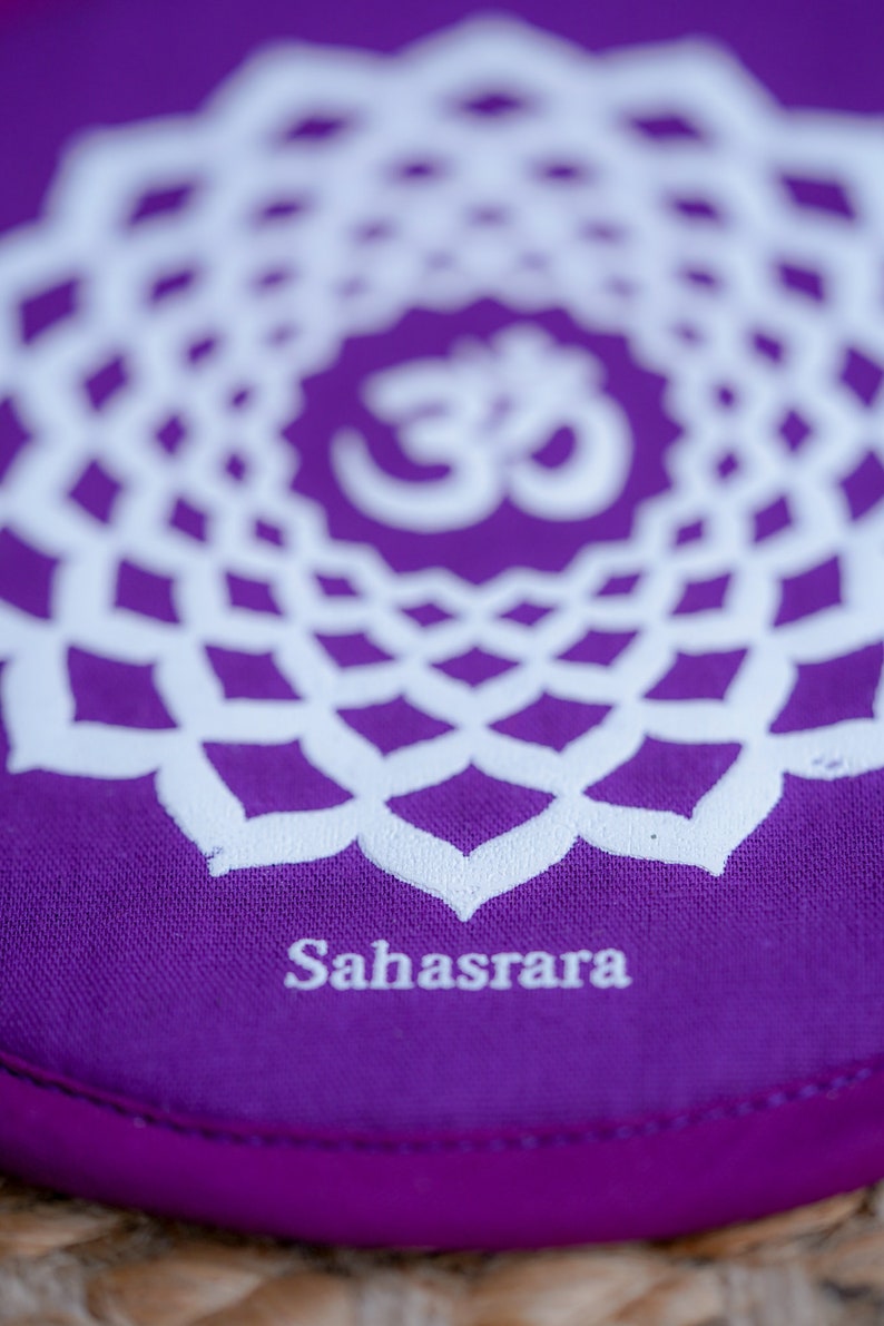 Op de afbeelding: Paarse meditatiekussen met een wit mandala-ontwerp en het woord "Sahasrara" gedrukt op de onderkant.