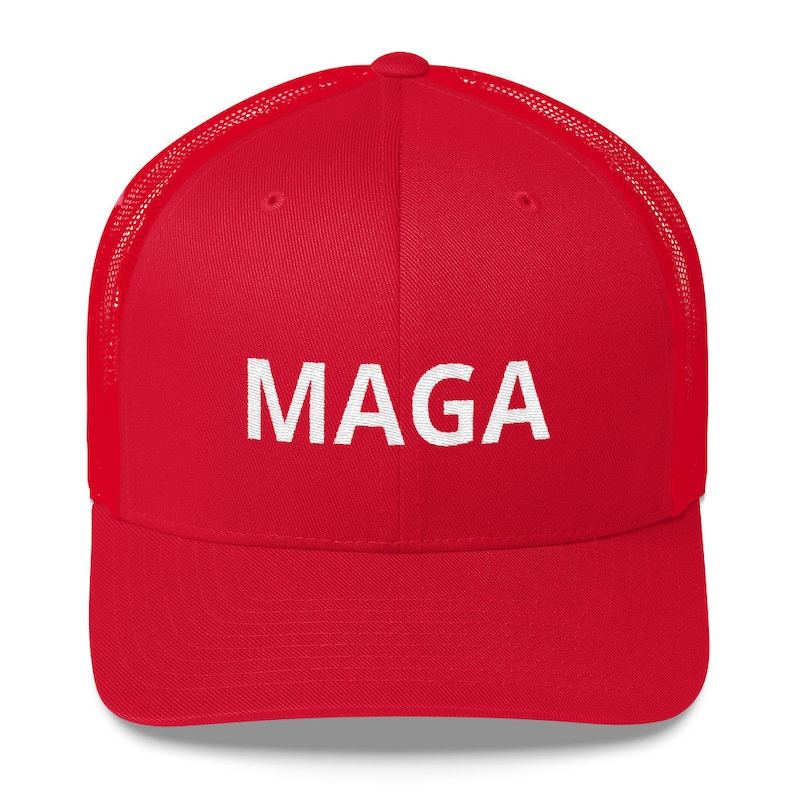 Op de afbeelding: Rode en zwarte mesh trucker cap met witte geborduurde tekst die "MAGA" zegt.