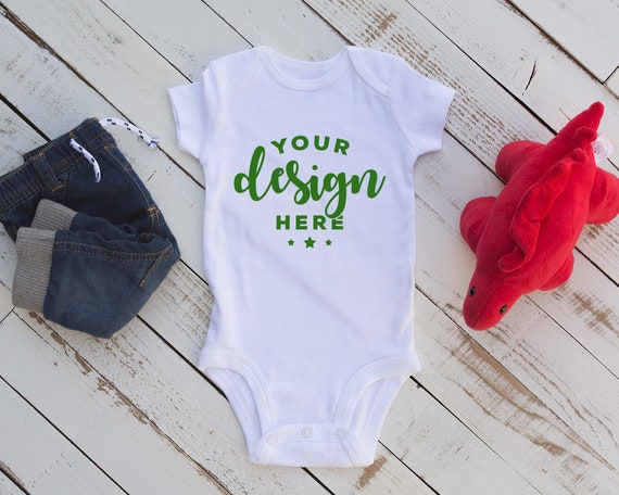 White Bodysuit Mockup With Infant Jeans And Red Dinosaur