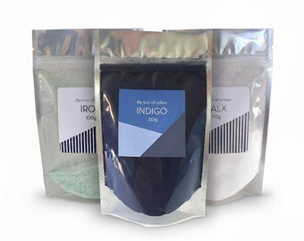 May include: Three foil pouches containing colored powders. The center pouch is indigo with a label that reads "INDIGO 50g". The other pouches contain IRO 100g and ALX 150g. Each pouch has a label with the text "the love of colour".