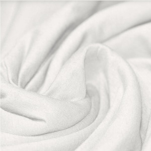 May include: Close-up of a white fabric with a smooth, soft texture. The fabric is folded and draped, creating a sense of movement and flow.