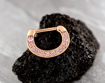 Pode incluir: Anel de septo de ouro rosa com uma fileira de pedras preciosas cor-de-rosa.