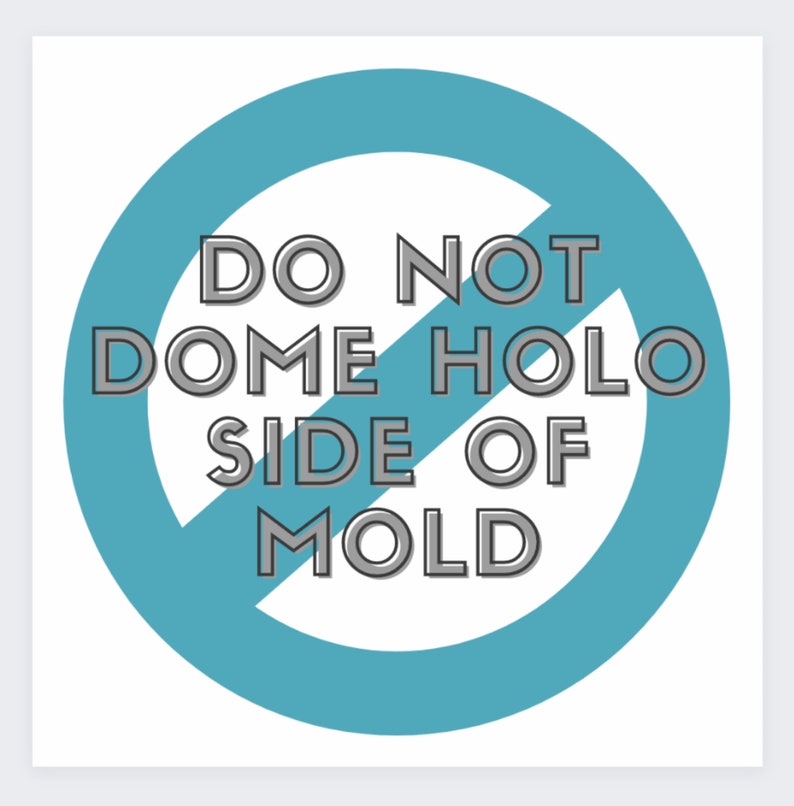 May include: A white square graphic with a teal blue circle and a diagonal line through it. The text within the circle reads "DO NOT DOME HOLO SIDE OF MOLD" in a gray, outlined font.