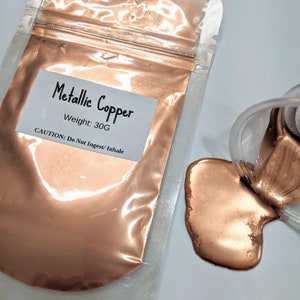 May include: A small resealable bag of metallic copper powder, with a label that reads "Metallic Copper, Weight: 30G, CAUTION: Do Not Ingest/Inhale". A small amount of the powder has been poured out of the bag onto a white surface.
