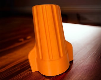 May include: Orange plastic wire connector with a ribbed design. The connector is designed to hold multiple wires together.