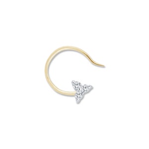 May include: A gold nose ring with a small, three-pronged diamond setting.
