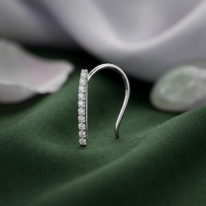 May include: A silver-toned ear climber earring featuring a vertical bar design set with a row of ten small, clear, round-cut stones. The earring has a curved wire backing that extends upward to secure the piece along the outer edge of the ear.