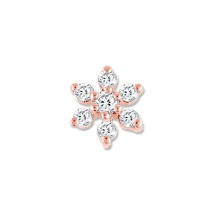 May include: A small, rose gold flower-shaped earring with clear cubic zirconia stones.