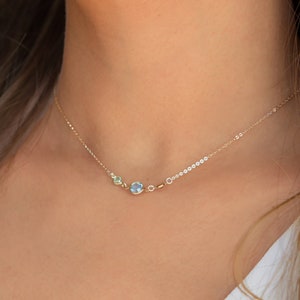 Peut inclure: Un collier en cha&icirc;ne dor&eacute;e avec trois petites pierres rondes. Les pierres sont bleu clair, bleu fonc&eacute; et vert clair.