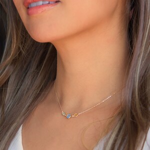 Peut inclure: Un collier en cha&icirc;ne dor&eacute;e avec trois petites pierres ovales. Les pierres sont vertes, bleues et jaunes.