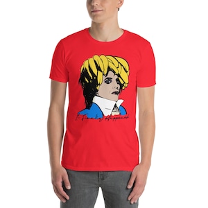Puede incluir: Camiseta roja con un retrato de estilo pop art. El retrato tiene pelo amarillo y detalles azules. El texto "It Finally Happened" está impreso debajo del retrato en escritura negra. La camiseta la lleva una persona.