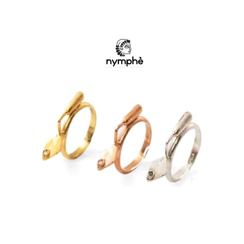 May include: Three gold rings with a small diamond on the side. The rings are in different shades of gold: yellow, rose, and white.