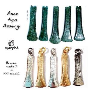 Peut inclure: Six pendentifs en bronze en forme de hache, également appelés Asce, de type Assergi. Les pendentifs sont en différentes finitions, notamment argent, or et bronze. Le texte "Asce tipo Assergi" et "Bronzo medio 3 - XXI sec.d.C." est visible sur l'image.