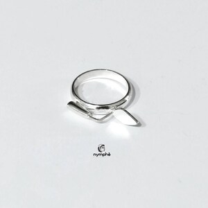 May include: A silver ring with a trowel design. The ring is simple and elegant.