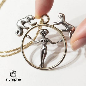 Peut inclure: Collier avec pendentif en argent représentant une femme à l'intérieur d'un cercle avec deux singes de chaque côté. Le collier est sur une chaîne en or.