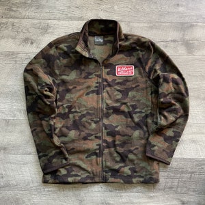 May include: A camouflage green fleece jacket with a red patch that says "Kildare Island Surfboard Co."