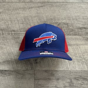 May include: A blue and red baseball cap with a white buffalo logo and the text "New Era" on the front.