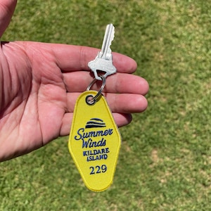 May include: Yellow motel key tag with blue embroidered text that reads "Summer Winds Kildare Island 229".