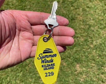 Può includere: Portachiavi di motel giallo con testo ricamato in blu che recita "Summer Winds Kildare Island 229".