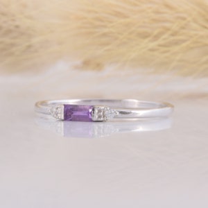 May include: A delicate silver ring with a purple rectangular gemstone and two small diamond accents.