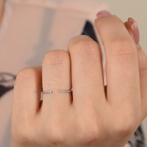 Peut inclure: Une délicate bague ouverte avec une rangée de petits diamants de chaque côté.