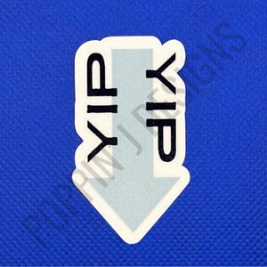 May include: A white sticker with a light blue arrow pointing down. The sticker has the letters "YIP" in black, arranged vertically. The background is a textured blue.