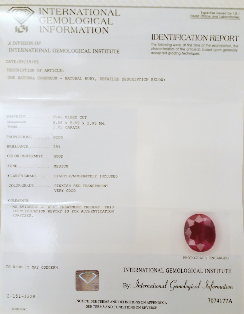 May include: An International Gemological Institute report details a natural ruby. The oval mixed-cut gemstone is described with measurements of 6.58 x 5.52 x 2.96 mm and a weight of 1.03 carats. The report includes color and clarity grades.