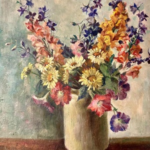 Könnte beinhalten: Ein Stillleben mit einem Strauß bunter Blumen in einer cremefarbenen Vase. Die Blumen umfassen gelbe, rosa, violette und orangefarbene Blüten. Die Vase steht auf einem Holztisch.