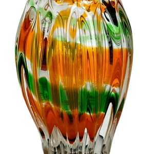 May include: A clear glass vase with a rippled texture and a swirling pattern of orange, green, and white.
