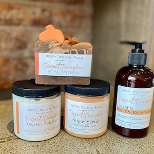 May include: A collection of Wispy Willow Farm bath and body products. Includes a bar of Perfect Pumpkin goat milk soap, a jar of body butter, a jar of sugar scrub, and a bottle of hand and body wash. The products have a fall theme.