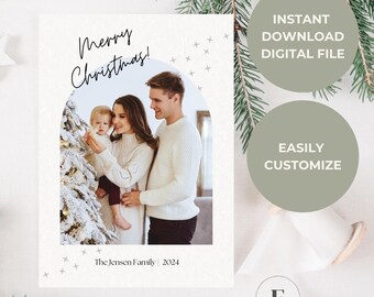 May include: A white Christmas card with a photo of a family standing in front of a Christmas tree. The text "Merry Christmas!" is written in black cursive script. The family's last name and the year are written below the photo.